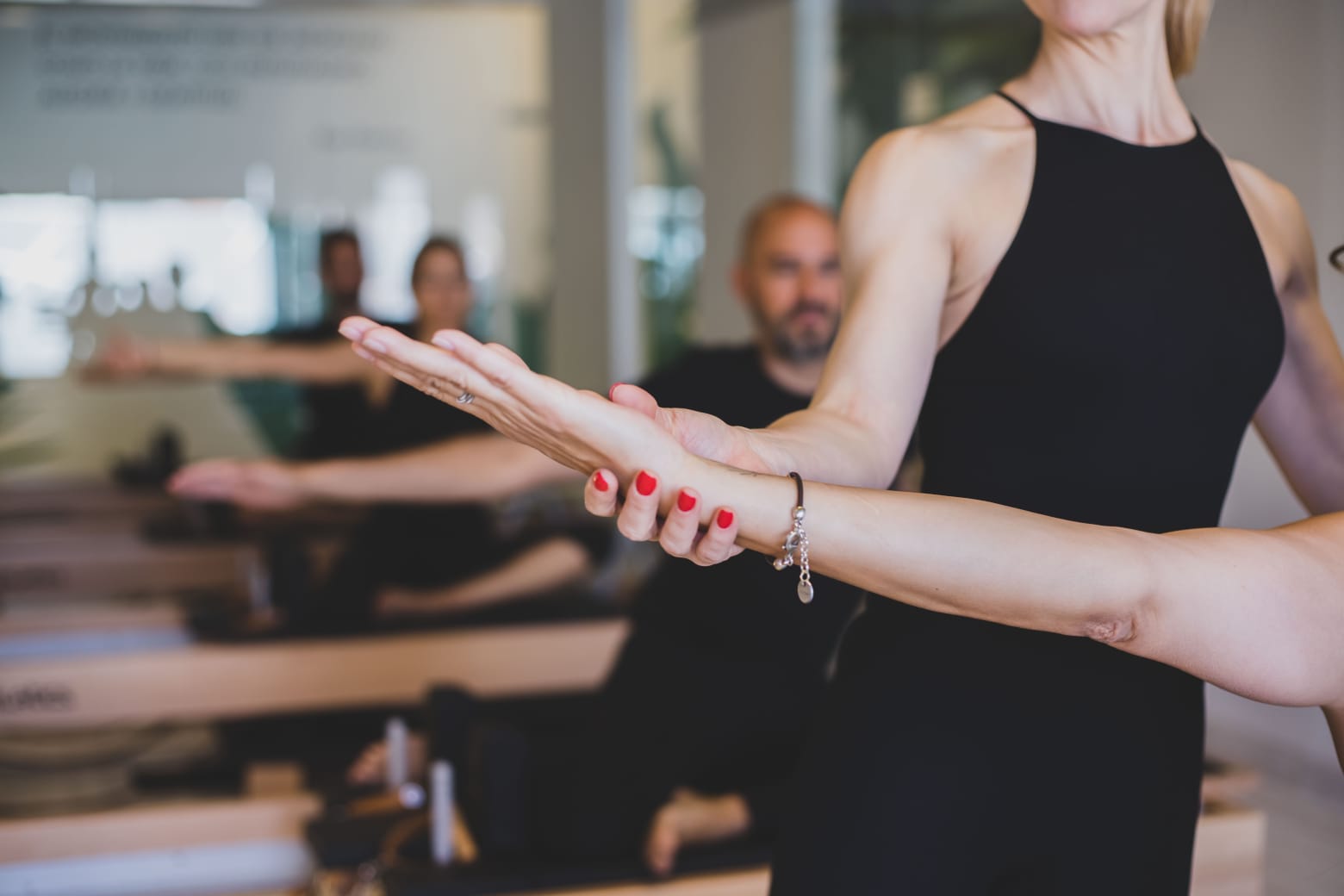 A serene woman performing a focused pilates pose in a sunlit studio